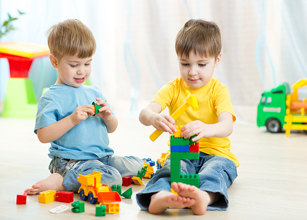 Kids boys play toys in playroom at nursery