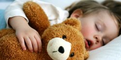 Boy sleeping with teddy bear