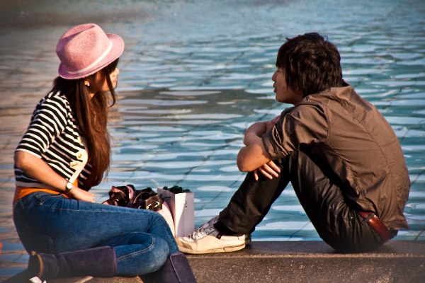 A teenage couple enjoy the sun by one of the Trafalgar Square fountains.